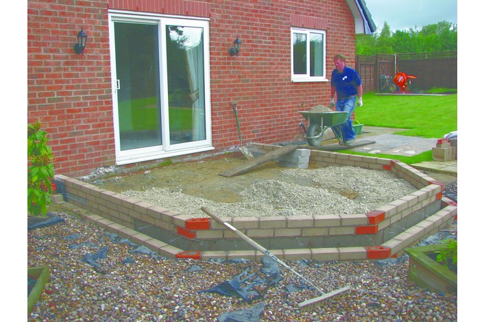 Aggregate is laid and compacted to a minimum of 100mm depth and a building screen of sand is laid on top.