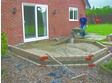 Aggregate is laid and compacted to a minimum of 100mm depth and a building screen of sand is laid on top.